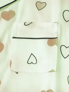 Detailed close-up showing heart print chest pocket on silky green women's pajama set