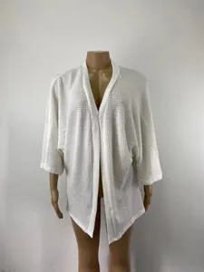 Détail d'un cardigan blanc en maille gaufrette avec manches trois-quarts larges
