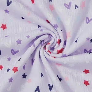 Detailopname van zachte lavendelkleurige gebreide katoen met sterren- en hartjesprint.