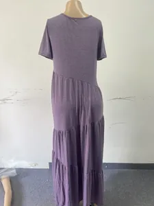 Back view of purple short sleeve tiered maxi dress with asymmetric hem design.
