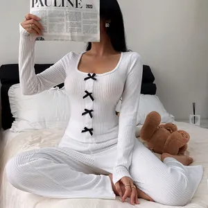 Cozy white ribbed knit pajama set with black bow accents and long sleeves