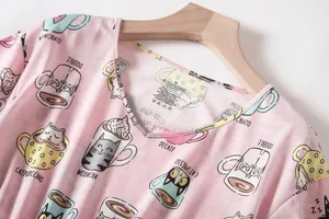 Detailweergave van een roze pyjamabovenstuk met kattenprint en V-hals