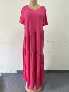 Close-up detail of the bright pink tiered asymmetrical skirt on a short sleeve maxi dress.