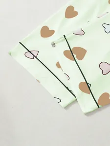 Close-up detail showing the cute heart print pattern and black piping on green pajama cuff