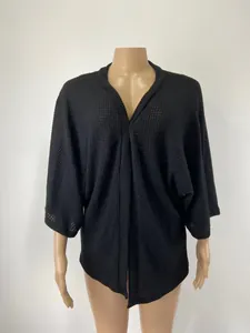 Détail de la texture maille gaufrée noire sur un gilet ample à manches trois-quarts