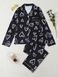 Close-up detail of women's black long-sleeved pajama set featuring white heart outlines