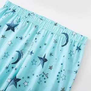 Detailopname van een lichtblauwe katoenen pyjamabroek met sterren- en maanpatroon