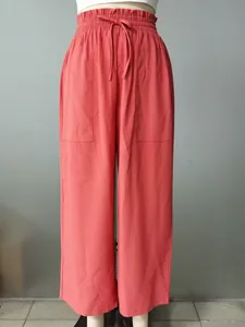 Front view of coral pink wide-leg casual trousers with elastic waist on a mannequin.