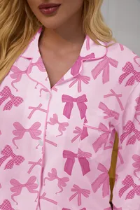 Close-up of pink long-sleeved pajama top with cute bow pattern and lapel collar