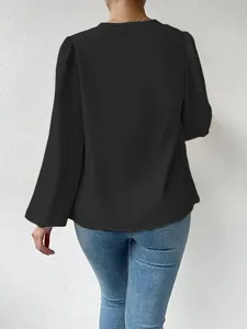 Achteraanzicht van een elegante zwarte damesblouse van chiffon met lange mouwen en losse pasvorm.