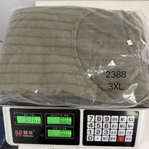 Detalle de un vestido de punto doblado en una báscula que marca un peso de 0,360 kg
