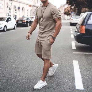 Stylish men's casual beige summer outfit with short sleeve t-shirt and matching shorts.