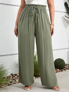 Detailed view of olive green wide-leg trousers featuring elastic waist and front pockets.