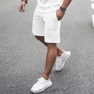 Close-up detail of white men's athletic shorts with drawstring and side pockets