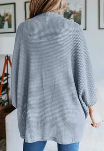 Vue arrière d'un cardigan gris en maille gaufrée pour femme avec manches chauve-souris amples.