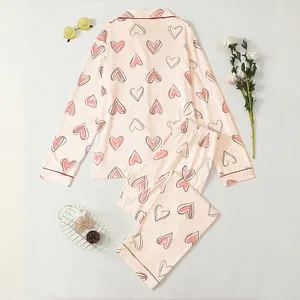 Women's soft peach pajama set with heart print, featuring long sleeves and a lapel collar
