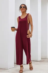 Full body shot of a woman in a casual burgundy sleeveless wide-leg jumpsuit for summer.