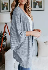 Vue détaillée d'un gilet en maille gaufrée gris pour femme avec manches 3/4 en intérieur