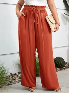 Detailed view of high-waisted elastic casual pants in terracotta with practical side pockets