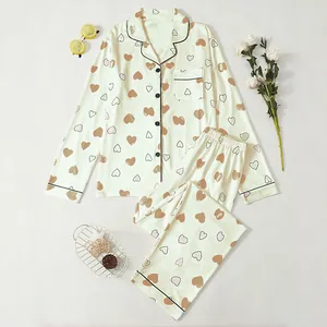Women's long-sleeve pajama set with heart print and notch collar in cream.
