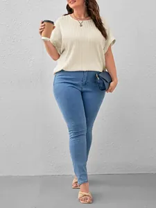 Plus size women's textured beige short sleeve t-shirt with light blue skinny jeans