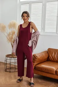 Elegant burgundy wide-leg jumpsuit styled with a knit cardigan in a cozy living room