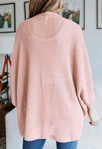 Vue arrière détaillée d'un gilet rose en maille gaufrée avec manches chauve-souris amples femme