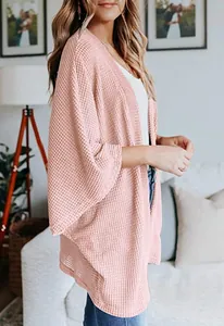 Vue de côté d'un cardigan rose en maille gaufre avec manches trois-quarts douces