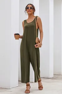 Model wearing a sleeveless olive green wide leg jumpsuit in a relaxed summer style