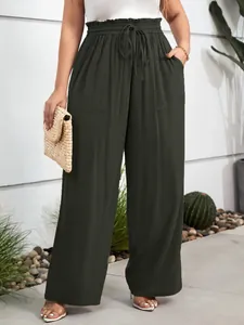 Detail view of dark green high-waisted wide-leg trousers with drawstring waist