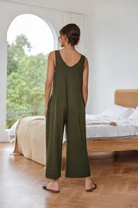 Olive green sleeveless wide-leg jumpsuit with V-back design in a minimalist bedroom