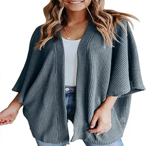 Vue détaillée de la texture en maille gaufrée douce sur un cardigan ample à manches trois-quarts.