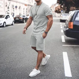 Model wearing light gray men's summer short sleeve and shorts set in casual style
