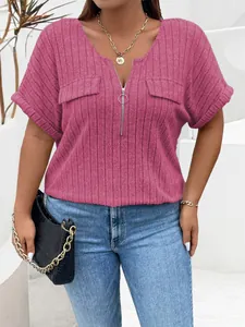 Detalle de blusa rosa de punto acanalado talla grande con cremallera y bolsillos.
