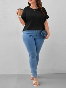 Plus size women's black rib-knit short sleeve top paired with blue jeans and a coffee cup