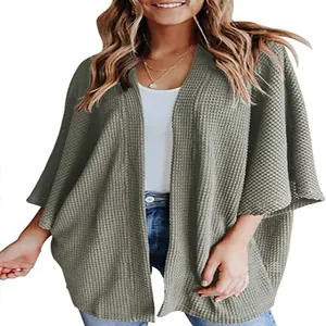 Détail d'un cardigan ample en maille gaufrée pour femme avec manches 3/4 en vert olive