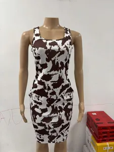 Close-up detail of a sleeveless bodycon dress featuring a bold cow print pattern.