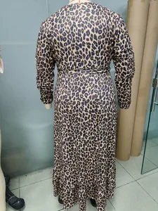 Back view of a trendy leopard print long sleeve maxi dress displayed on a mannequin