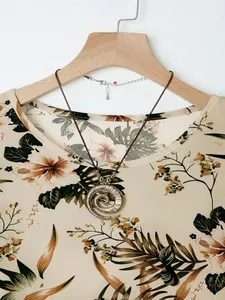 Close-up of bohemian spiral metal pendant necklace on a floral print summer shirt