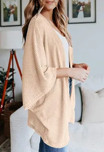 Vue latérale du gilet beige en maille gaufrée avec manches trois-quarts amples