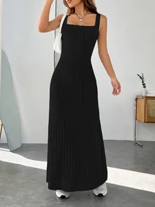 Full-length shot of a black ribbed maxi dress on a model in a minimalist indoor setting