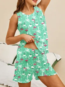 Close-up of green pajama set with pink flamingo and palm tree prints for women