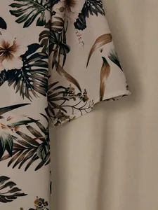 Macro detail of the vibrant tropical hibiscus floral print on lightweight fabric sleeve
