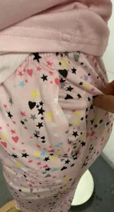 Vue détaillée de la poche latérale d'un pantalon rose avec motifs de cœurs et d'étoiles