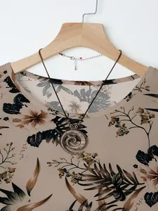 Detail view of floral print top with vintage spiral pendant necklace on hanger