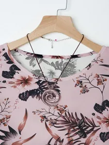 Detailed view of copper spiral necklace pendant on pink floral printed summer blouse