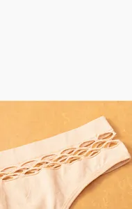 Detailed view of women's beige seamless thong with breathable hollow mesh design on the fabric.