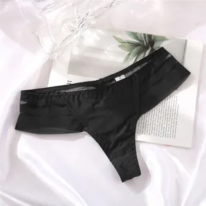 Detailed macro view of a black seamless ice silk thong on a white satin background