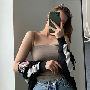 Close-up detail of a brown seamless camisole tank top with thin straps on a model