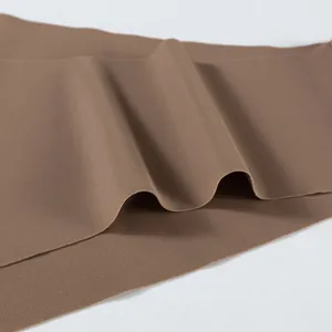 Close-up van naadloze bruine ijshuidstof voor ademend sportondergoed voor dames.